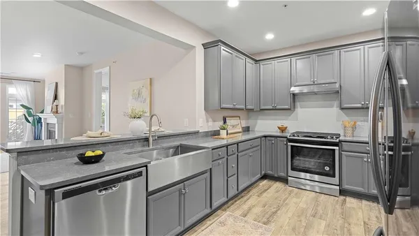 a kitchen with granite countertop a sink stainless steel appliances and cabinets