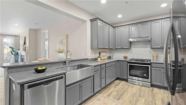 a kitchen with granite countertop a sink stainless steel appliances and cabinets