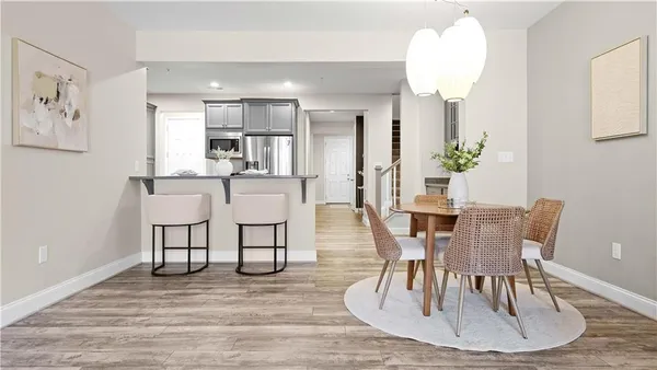 a dining room with wooden floor a chandelier a wooden table and chairs