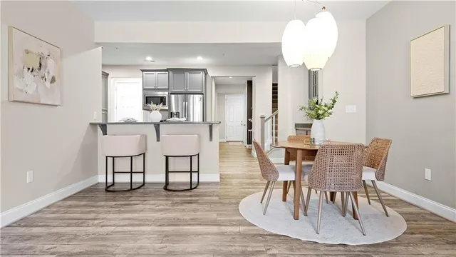 a dining room with wooden floor a chandelier a wooden table and chairs