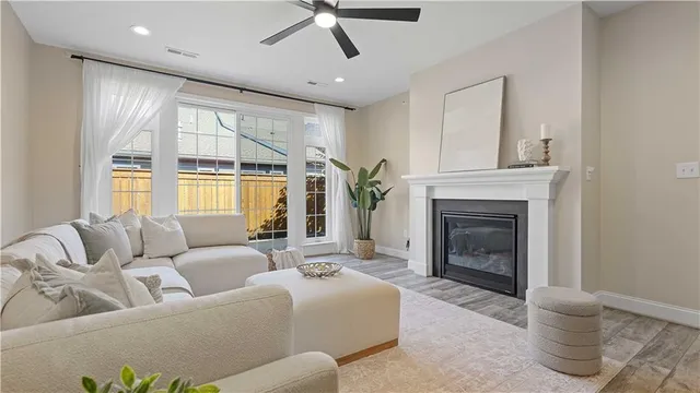 a living room with fireplace furniture and a large window