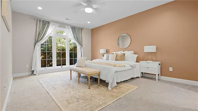 a bed sitting in a spacious bedroom next to a window