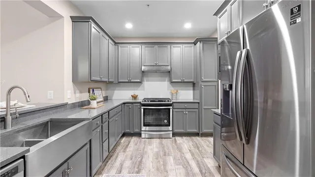 a kitchen with stainless steel appliances a refrigerator a stove and a refrigerator