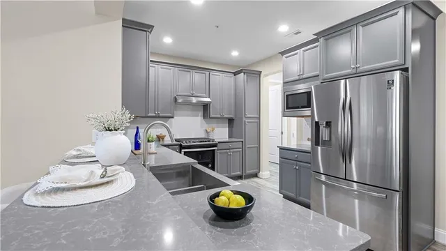 a kitchen that has a sink a stove and cabinets