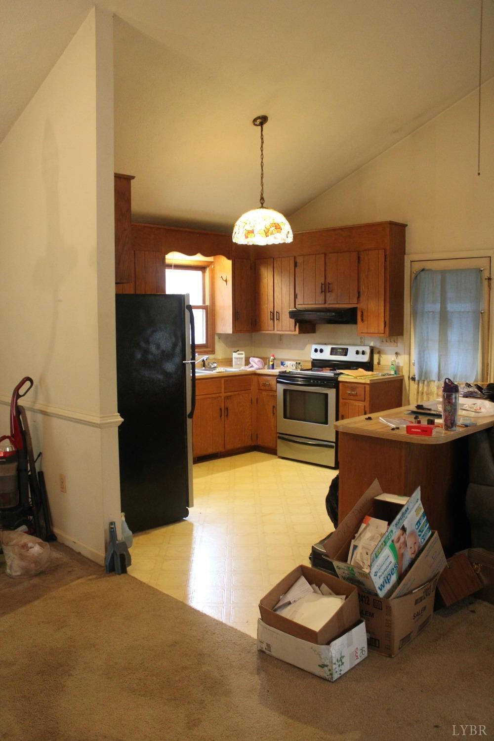 3260 West Perch Road Monroe, VA 24574 - Photo 5 of 12 a kitchen with stainless steel appliances granite countertop a stove a refrigerator a sink dishwasher with a dining table and chairs