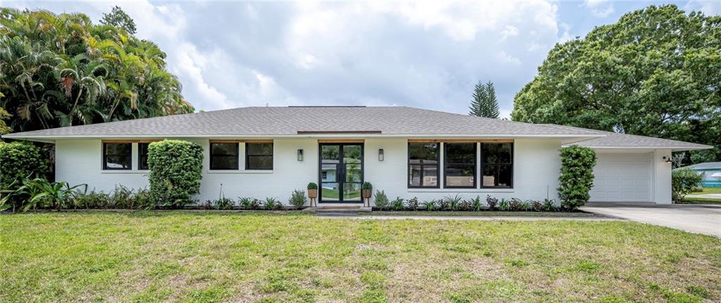 2575 15th Street Vero Beach, FL 32960 - Photo 1 of 36 front view of a house with potted plants and a yard