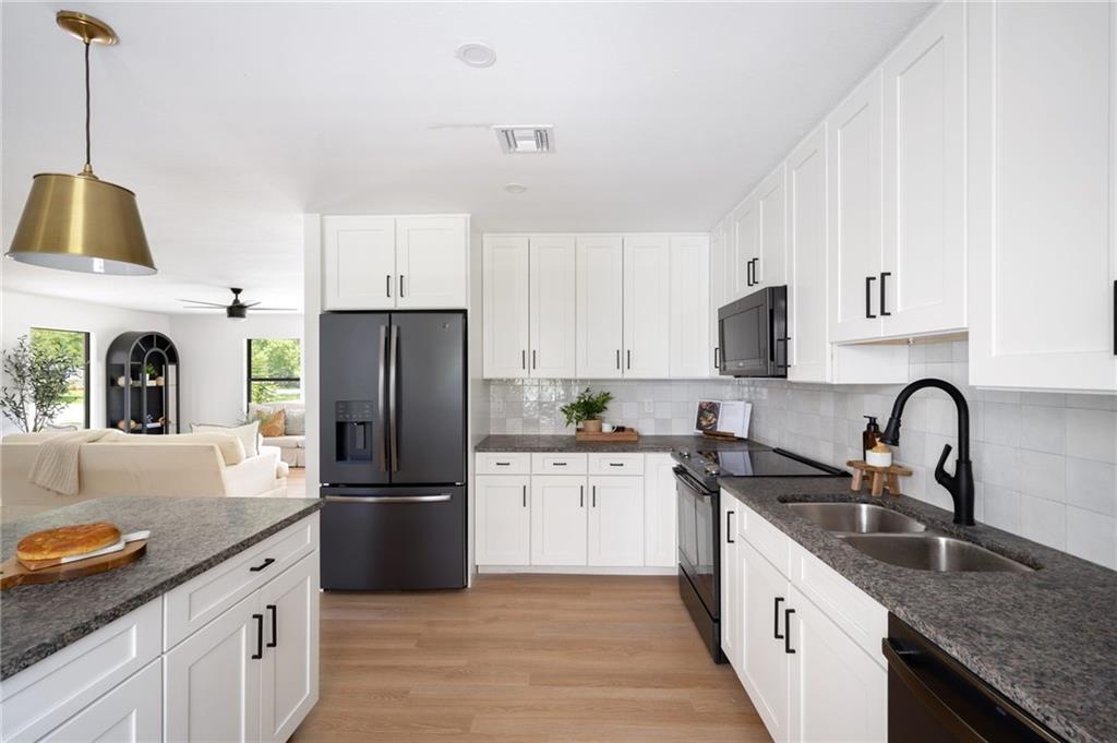 2575 15th Street Vero Beach, FL 32960 - Photo 22 of 36 a kitchen with granite countertop a sink stainless steel appliances and white cabinets