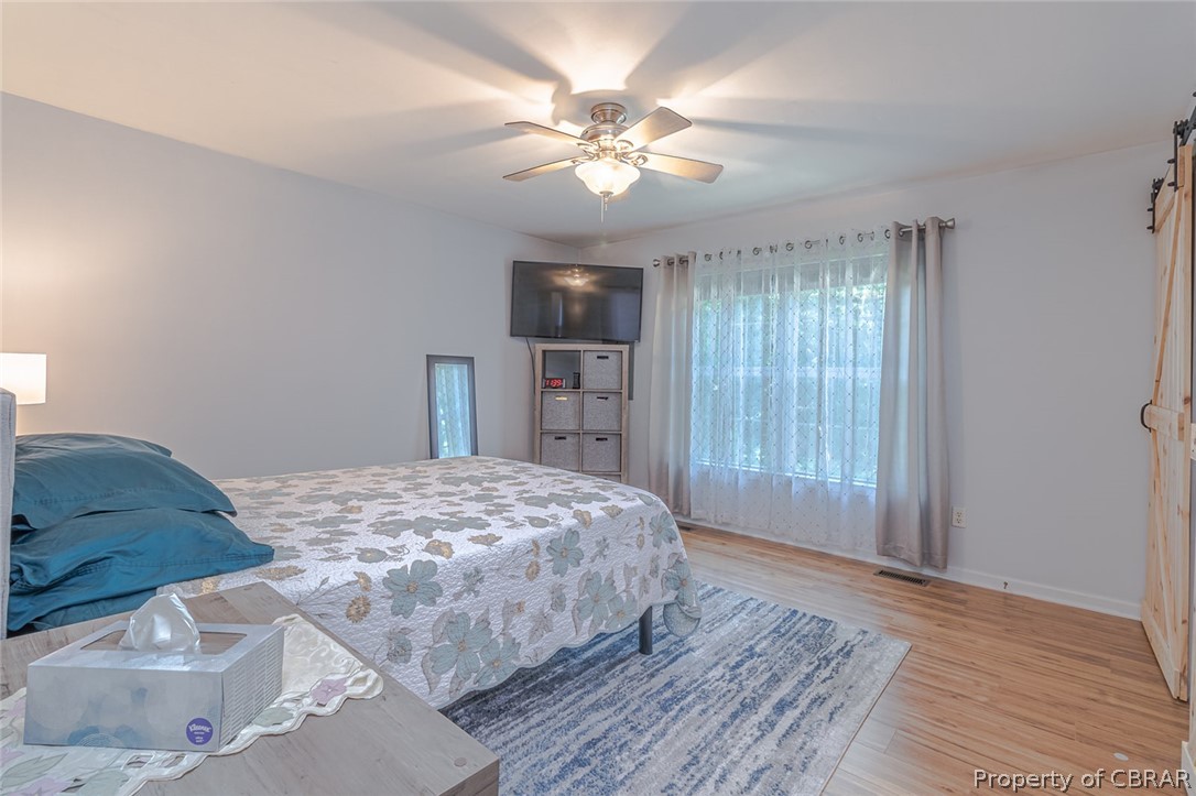11654 Courthouse Road Lancaster, VA 22503 - Photo 16 of 35 a bedroom with a large bed and a chandelier