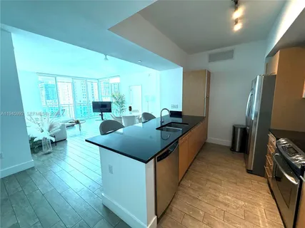 a kitchen with a table chairs and wooden floor