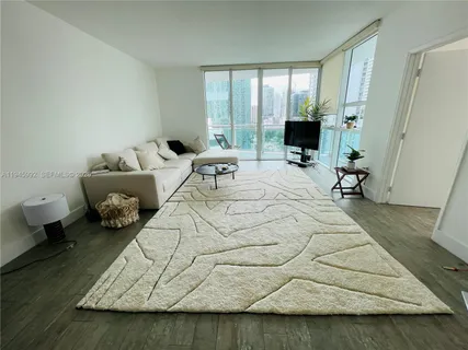 a bedroom with a bed and a flat tv screen next to a window