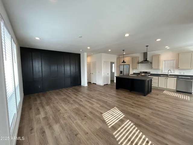 a large kitchen with kitchen island granite countertop wooden cabinets and stainless steel appliances