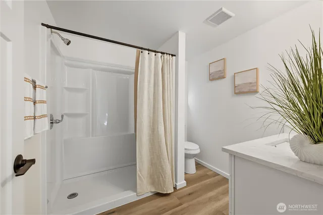 a bathroom with a shower a toilet and a sink