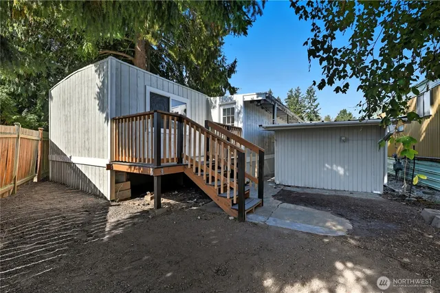a view of a house with wooden fence and a tree