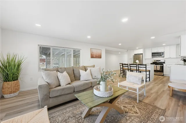 a living room with furniture kitchen and a table