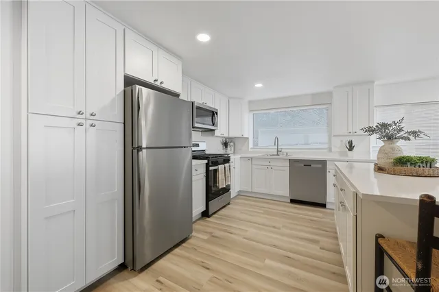 a kitchen with a refrigerator a sink and a stove top oven
