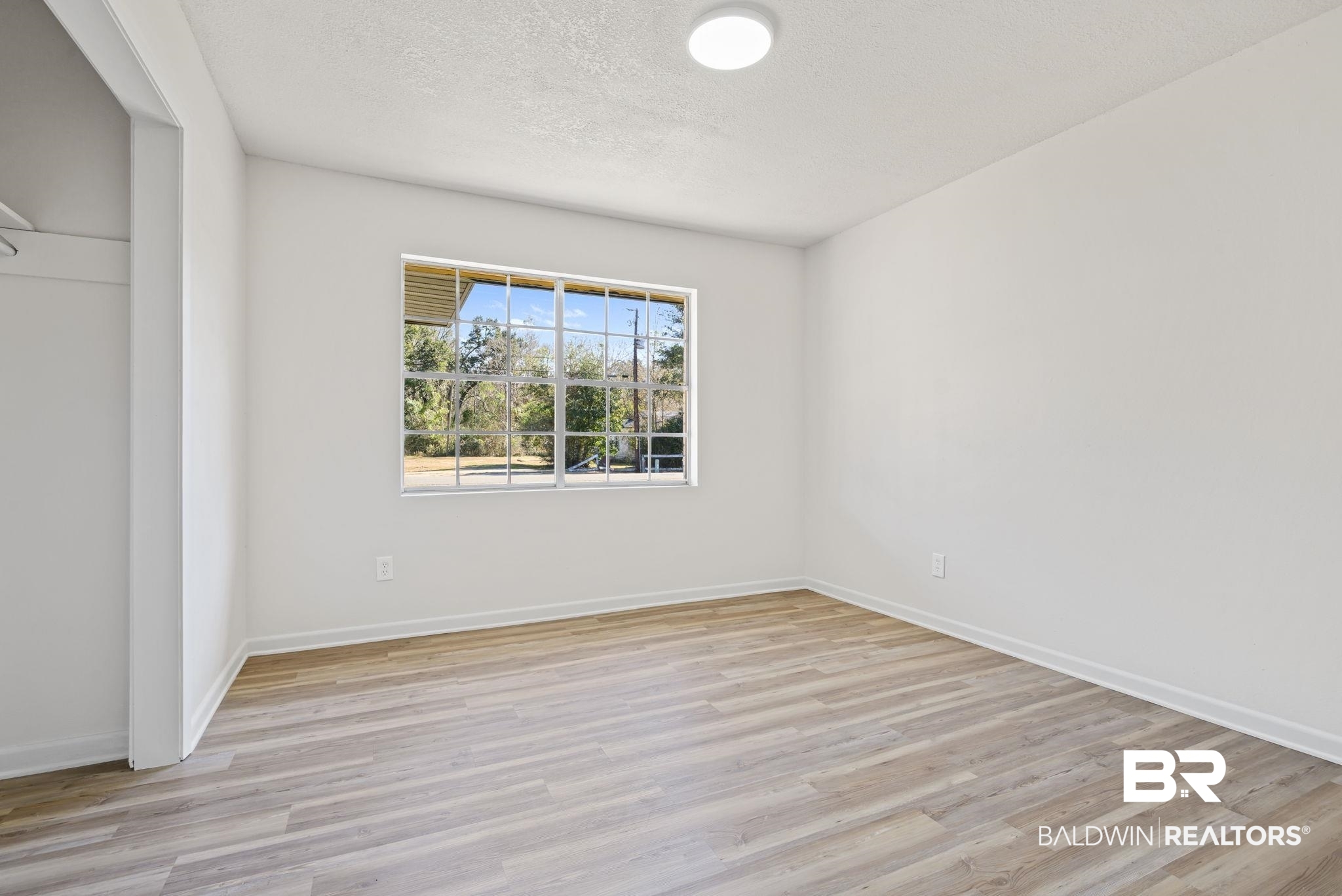 910 Moran Street Bay Minette, AL 36507 - Photo 13 of 20 Unfurnished room with light wood-style floors and a textured ceiling