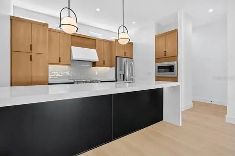 a kitchen with granite countertop a sink cabinets and stainless steel appliances