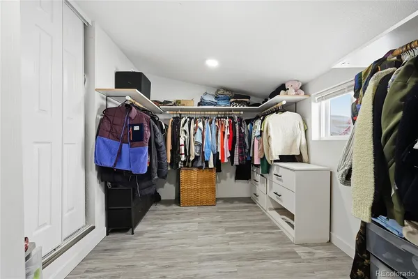 a view of walk in closet with clothes and shoes