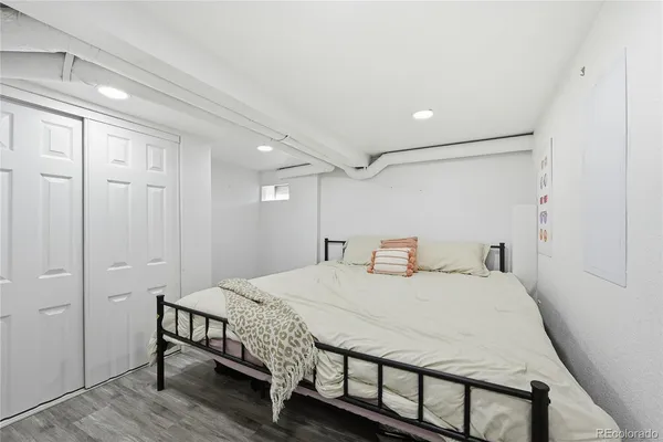 a bedroom with a bed and a refrigerator