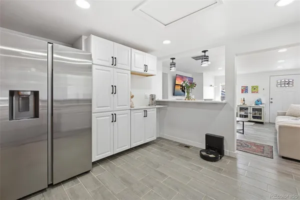 a kitchen with granite countertop a refrigerator and a sink