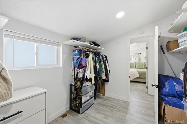 a view of a storage & utility room with closet dryer and hardwood floor