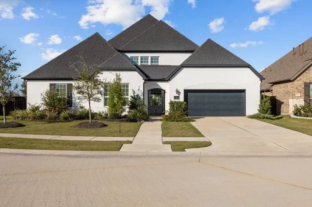 a spacious bathroom with a double vanity sink a mirror and a bathtub