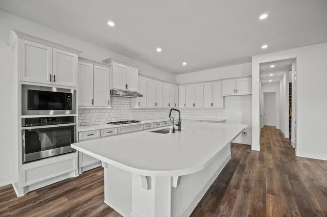 a view of an empty room with a window and a dresser
