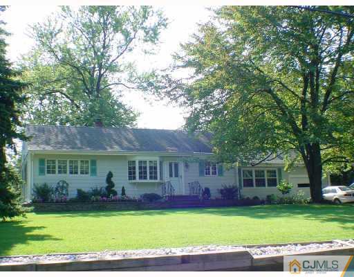 a front view of a house with a garden and swimming pool