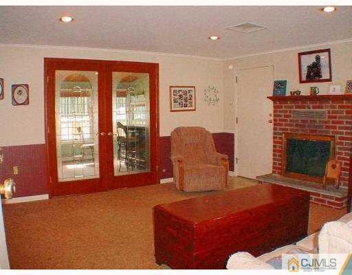 397 Chain O' Hills Road Colonia, NJ 07067 - Photo 2 of 10 a living room with furniture a fireplace and a floor to ceiling window