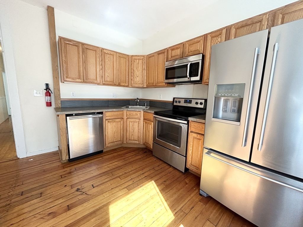 1 Folsom Avenue, Unit 2 Boston, MA 02120 - Photo 1 of 9 a kitchen with stainless steel appliances granite countertop a refrigerator a stove a sink and a microwave