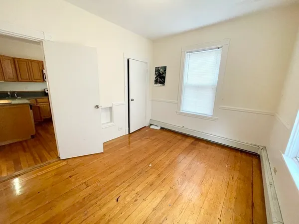 a view of empty room with wooden floor