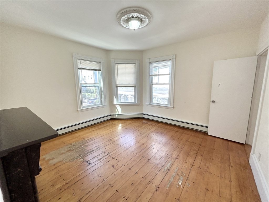 1 Folsom Avenue, Unit 2 Boston, MA 02120 - Photo 4 of 9 an empty room with wooden floor and windows