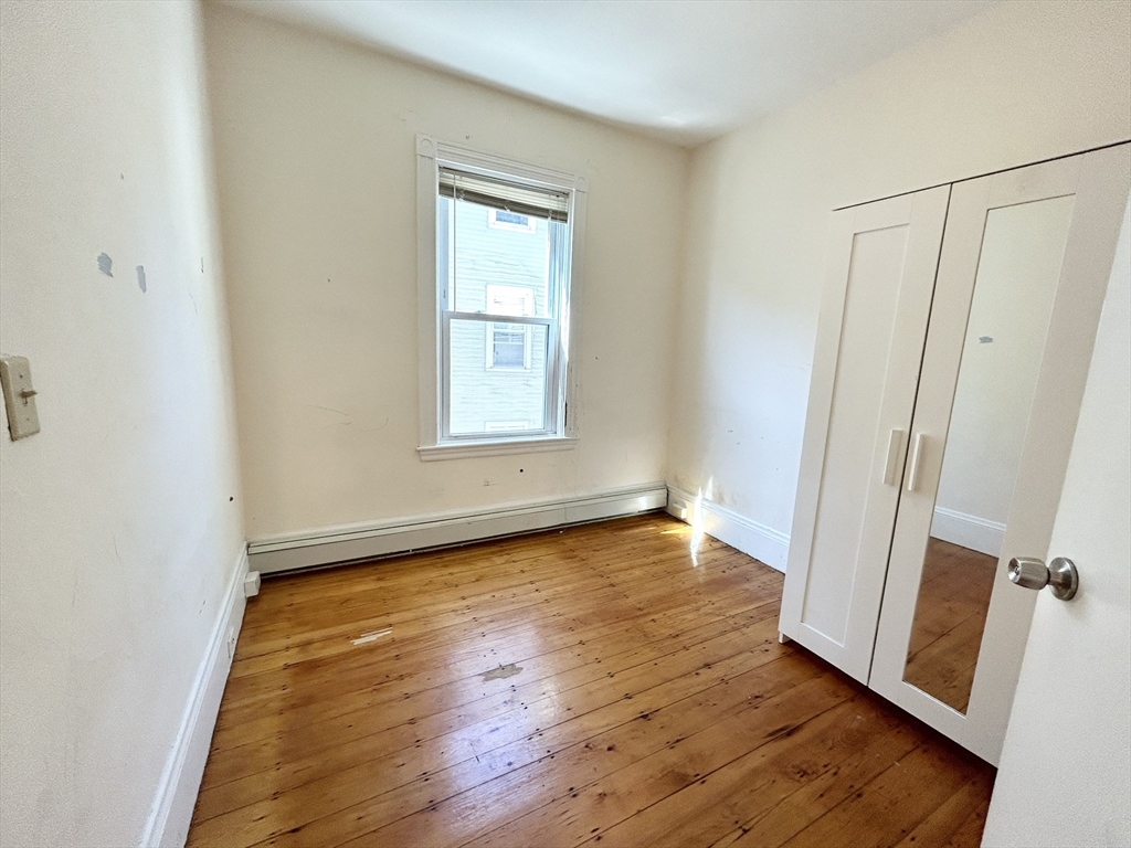 1 Folsom Avenue, Unit 2 Boston, MA 02120 - Photo 7 of 9 an empty room with wooden floor and window