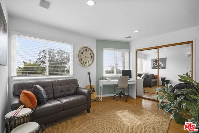 a bedroom with a bed and large windows