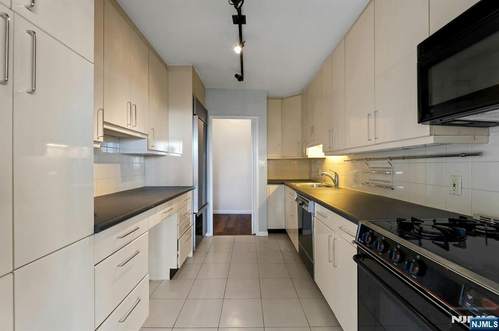 5 Horizon Road, Unit 503 Fort Lee, NJ 07024 - Photo 17 of 45 a kitchen with granite countertop a sink and stainless steel appliances