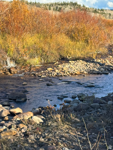1663 Lancer Lane Evanston, UT 82930 - Photo 56 of 101 Rocky stream featuring clear water, surrounding autumnal foliage, and distant evergreen trees