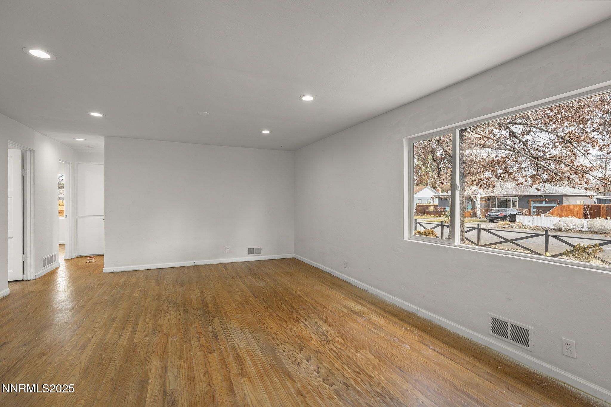 1085 Memory Lane Reno, NV 89509 - Photo 4 of 21 a view of an empty room with wooden floor and a window