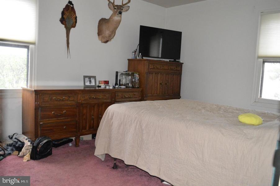 131 Club House Road Brick, NJ 08723 - Photo 11 of 20 a bedroom with a bed and a chandelier