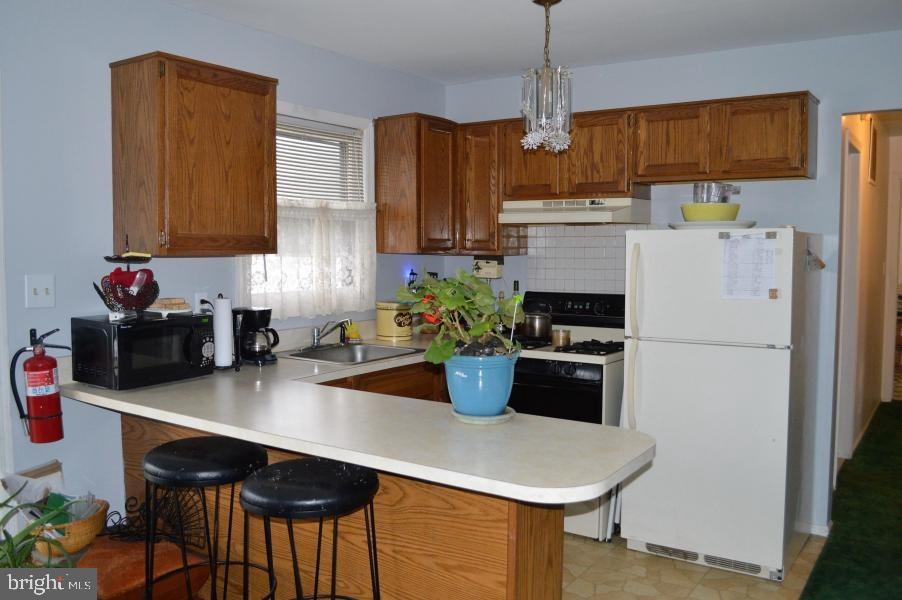131 Club House Road Brick, NJ 08723 - Photo 16 of 20 a kitchen with a sink a stove and a refrigerator