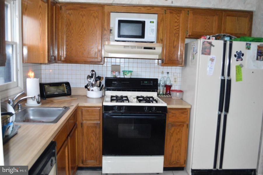 131 Club House Road Brick, NJ 08723 - Photo 4 of 20 a kitchen with a stove a refrigerator and a sink