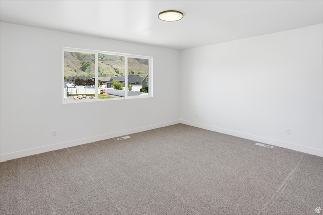 1315 West 3200 South, Unit 17 Perry, UT 84302 - Photo 36 of 58 Spacious room featuring neutral carpet, white walls, and a large multi-pane window