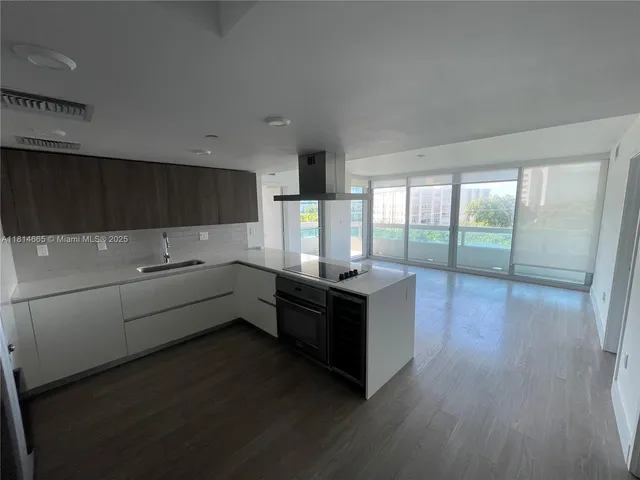 a kitchen with granite countertop a stove and wooden floor