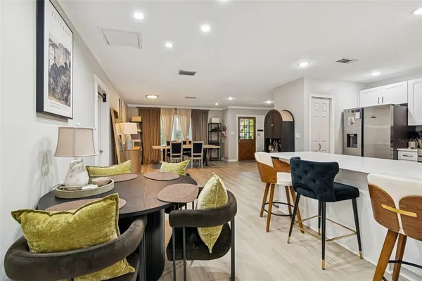 a kitchen with stainless steel appliances granite countertop a refrigerator a stove a sink dishwasher and white cabinets with wooden floors