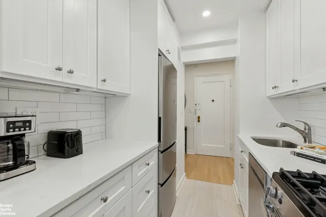 a kitchen with white cabinets and a stove