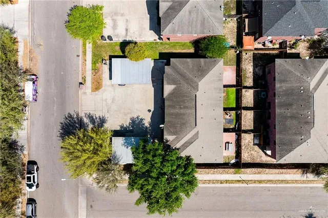 an aerial view of a house with a yard and large trees