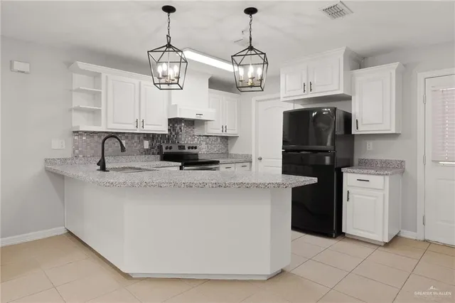 a kitchen with stainless steel appliances granite countertop a sink a stove a refrigerator and center island