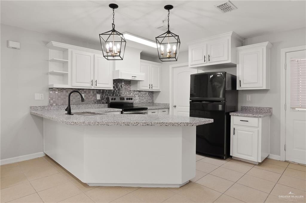 213 South 49th Street, Unit 2 McAllen, TX 78501 - Photo 4 of 23 a kitchen with stainless steel appliances granite countertop a sink a stove a refrigerator and center island