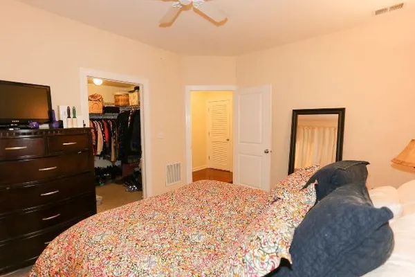 a bedroom with a bed and a flat tv screen on dresser