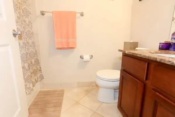 a bathroom with a granite countertop toilet and a sink