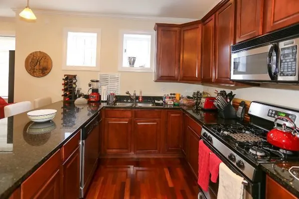 a kitchen with granite countertop a sink stove and cabinets